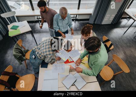 College students collaborating with professor in modern classroom Stock Photo