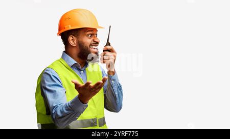 Mad construction site supervisor yelling in two-way radio, white background Stock Photo