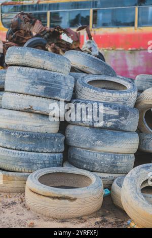 A pile of discarded tires in a junkyard, taking up space and posing a potential environmental hazard. Stock Photo