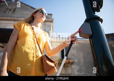 blind woman at traffic lights on pedestrian crossing Stock Photo