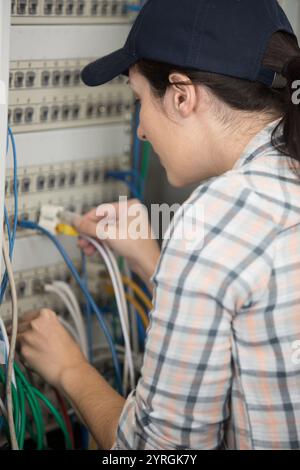 woman works in the server room and switches the wires Stock Photo
