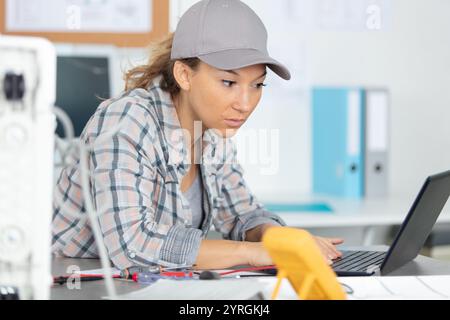 young female engineer is focused on repairing electronic equipment Stock Photo