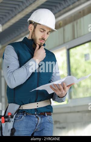 young builder contemplating plans Stock Photo