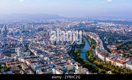 Breathtaking aerial view of Vienna, Austria, showcasing the historic cityscape, the serene Danube Canal, and iconic landmarks under a clear sky. Stock Photo