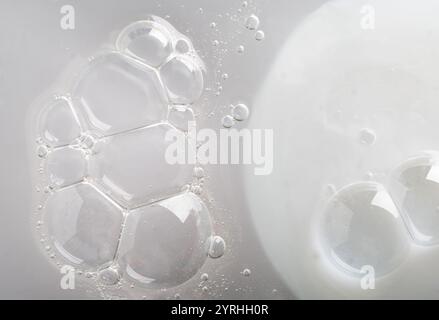Close-up of iridescent bubbles in a cosmetic liquid, creating an abstract pattern The image showcases the smooth texture and delicate reflections, per Stock Photo