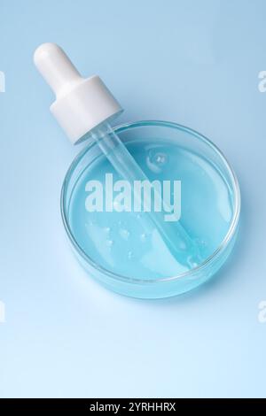 Petri dish with light blue liquid sample on white background, top view ...