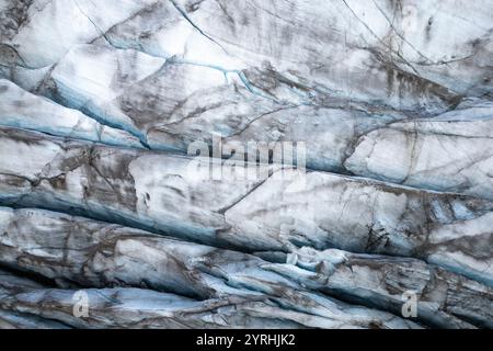 Close-up of a glacier’s surface, highlighting its intricate layers and textures The image captures the icy blues and rough patterns, illustrating the Stock Photo