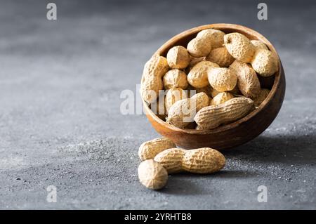 Peanut with nutshell not peeled nut on rustic background, composition of peanuts, concept of nuts Stock Photo