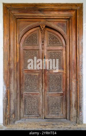 Closeup view of ancient traditional wooden door with floral and geometric carving pattern, Istaravshan, Sughd, Tajikistan Stock Photo