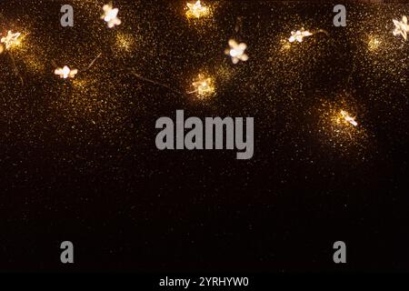 Magic gold background with stars lights bokeh. Festive Christmas background. New Year golden wallpaper at night. Free copy space for design Stock Photo