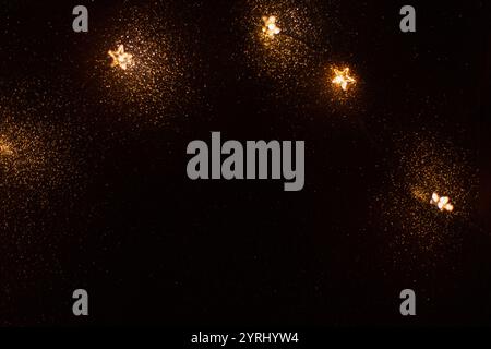 Magic gold background with stars lights bokeh. Festive Christmas background. New Year golden wallpaper at night. Free copy space for design Stock Photo