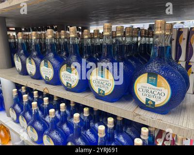 Bottles of Blue Curacao liqueur on sale at a duty free store at Curacao airport. Stock Photo