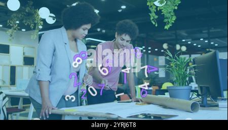Numbers image over two colleagues reviewing architectural plans in modern office Stock Photo