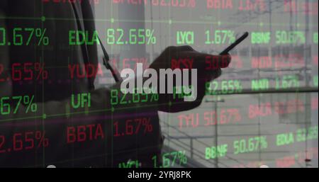 Image of young african american man analyzes stock market data on screens Stock Photo