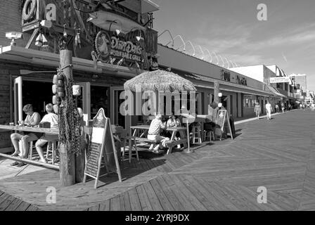 Tourists enjoying a meal at a sidewalk café along the bustling boardwalk in Myrtle Beach, South Carolina, USA. Stock Photo