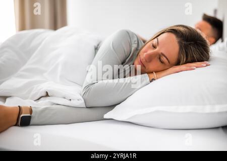 Young married couple is sleeping in their bed. Stock Photo