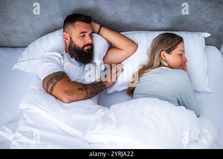 Young married couple is sleeping in their bed. Stock Photo