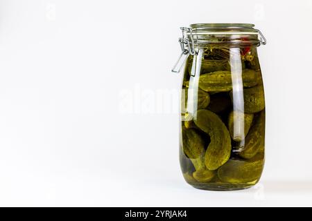 Pickled cucumbers in a large jar on a white background. Vegetable preserves. Stock Photo