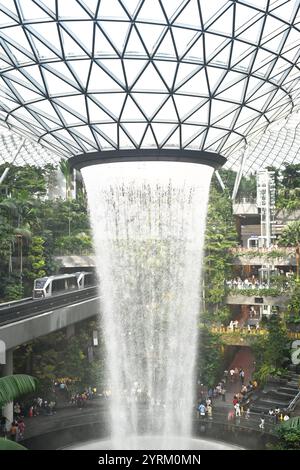 Skytrain passthrough Indoor Waterfall with Lush Greenery at Singapore Changi Airport Stock Photo