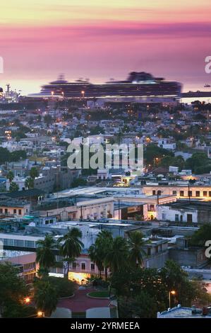 MEXICO-Sinaloa State-Mazatlan: Mazatlan View from Cerro de la Neveria Hill with moving Cruise ship/ Dawn Stock Photo