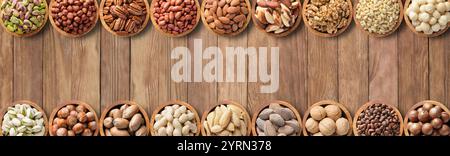 mix nuts and seeds in wooden bowls, top view. healthy food background on table. Stock Photo