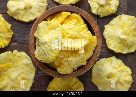 dried fruit, rings pineapple in bowl on wooden table background. Stock Photo