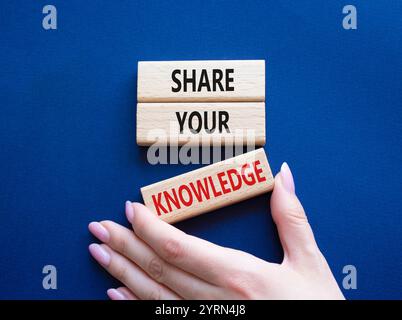 Share your knowledge symbol. Concept word Share your knowledge on wooden blocks. Businessman hand. Beautiful deep blue background. Business and Share Stock Photo