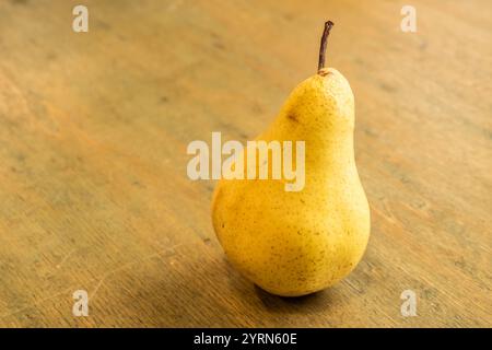 Ripe yellow organic pear on wooden background. Close-up. Stock Photo