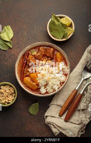 Delicious massaman curry with beef, potatoes, rice, and peanuts is served in bowl top view, Thai cuisine Stock Photo