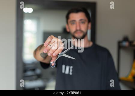 Man barbershop professional hairdresser holding scissors in hand in hair salon Stock Photo