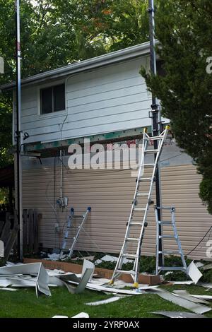 Home siding replacement in progress with three stages visible on one side.l Stock Photo
