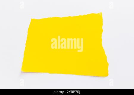 Yellow torn paper lies on a white background. Text note Stock Photo