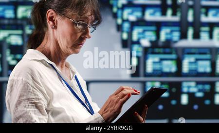 Precise system administrator in data center equipped to handle complex computing operations, doing regular upgrades to server parts, increasing processing power to prevent collapse Stock Photo