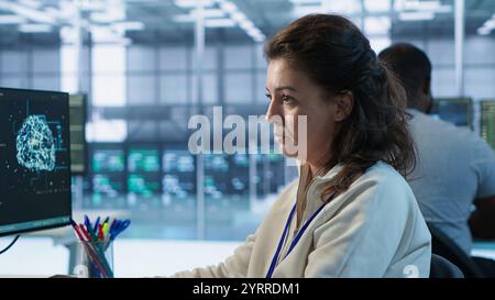 Portrait of smiling technician using PC to do maintenance on artificial intelligence neural networks. Cheerful admin using AI system aiding in processing and transmitting information, camera A Stock Photo