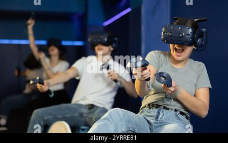 girl in virtual reality glasses controls superhero with joystick in exciting action game simulator Stock Photo