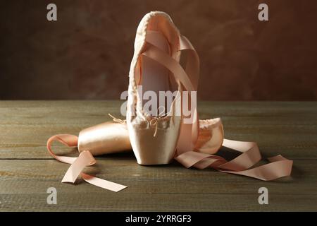 Pair of beautiful pointe shoes on wooden table Stock Photo