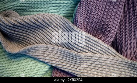 The background is filled with knitted fabric of different colors. Gray, turquoise, purple. Clothing. Gray diagonal stripe from above. Under it are tur Stock Photo