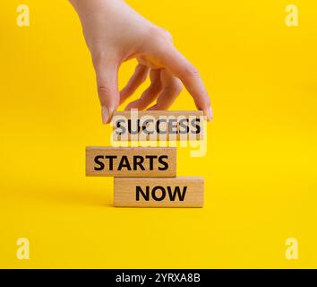 Success Starts Now symbol. Concept words Success Starts Now on wooden blocks. Businessman hand. Beautiful yellow background. Psychological social and Stock Photo