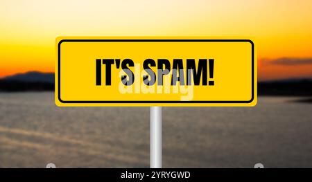It's spam message written on yellow sign with blurry lake background. Conceptual it's spam symbol. Copy space. Stock Photo