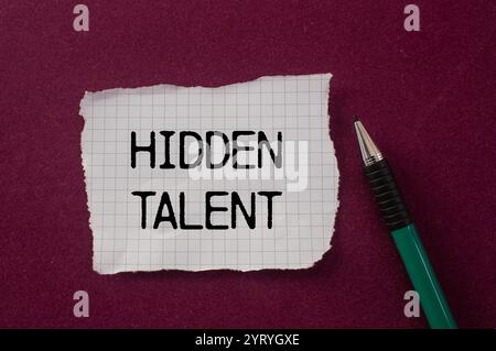Hidden talent message written on ripped torn paper piece with purple background. Conceptual hidden talent symbol. Copy space. Stock Photo