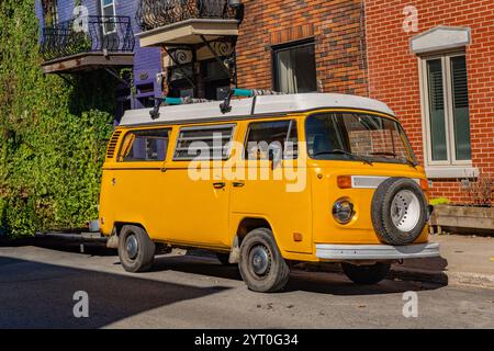 Montreal, QC, Canada-September 30, 2024: Bright yellow  VW combi camper van parked on street. Stock Photo