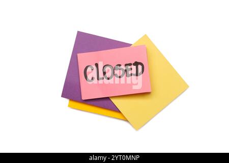 Closed single word handwritten on a pink adhesive paper note on a pile of colored paper notes on a white background Stock Photo
