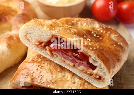 Pieces of fresh calzone pizza on wooden table, closeup Stock Photo