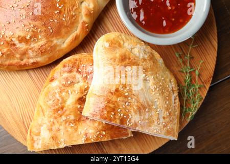 Pieces of calzone pizza served on wooden table, top view Stock Photo