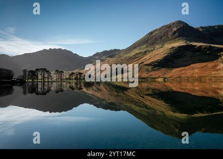 Classic view of the Buttermere Pines and Haystacks Fell reflected in Buttermere on a beautiful calm spring morning Stock Photo