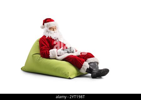 Santa Claus sitting on a beanbag isolated on white background Stock Photo