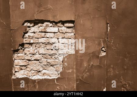 Exposed brick wall with peeling plaster in Mocha and Mousse tones Stock Photo