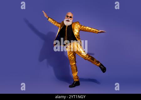 Full body photo of bearded gentleman spread hands dancing wear fashionable golden clothes isolated on violet color background Stock Photo