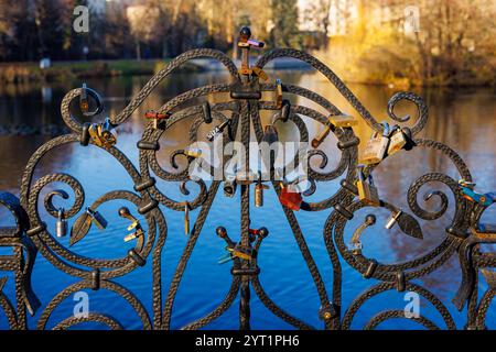 A cast-iron park fence with the locks of the newlyweds hanging on it. Stock Photo