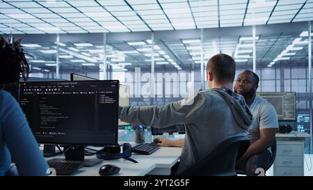 Manager admonishing programmer after making error damaging high tech data center. Supervisor scolding IT staff member after doing mistake in server room affecting supercomputers, camera B Stock Photo
